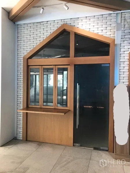 พื้นที่ขายปลีก ให้เช่าในWatthana, Bangkok - พื้นที่ค้าปลีกขนาดกะทัดรัด หน้าร้านกระจกกรอบไม้ มีช่องบริการและประตูกระจกสีดำ คู่กับผนังอิฐขาว.