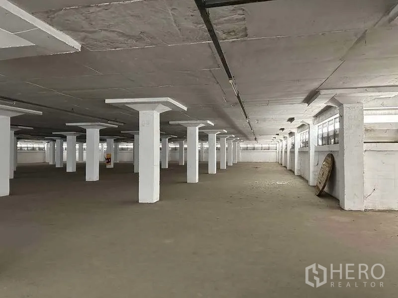 Factory for rent in Mueang Samut Prakan, Samut Prakan - Long warehouse floor showing rows of pillars and ceiling-mounted utilities.