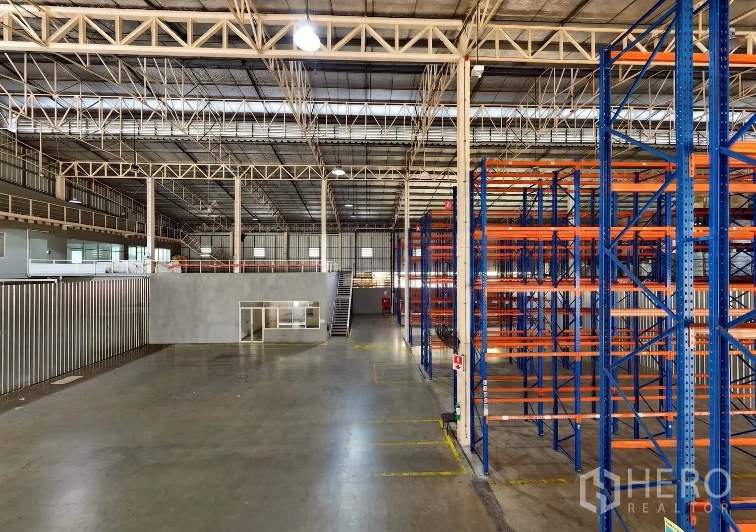 Warehouse for rent in Bang Sue, Bangkok - Warehouse interior showing mezzanine office, wide floor space, and storage racks.