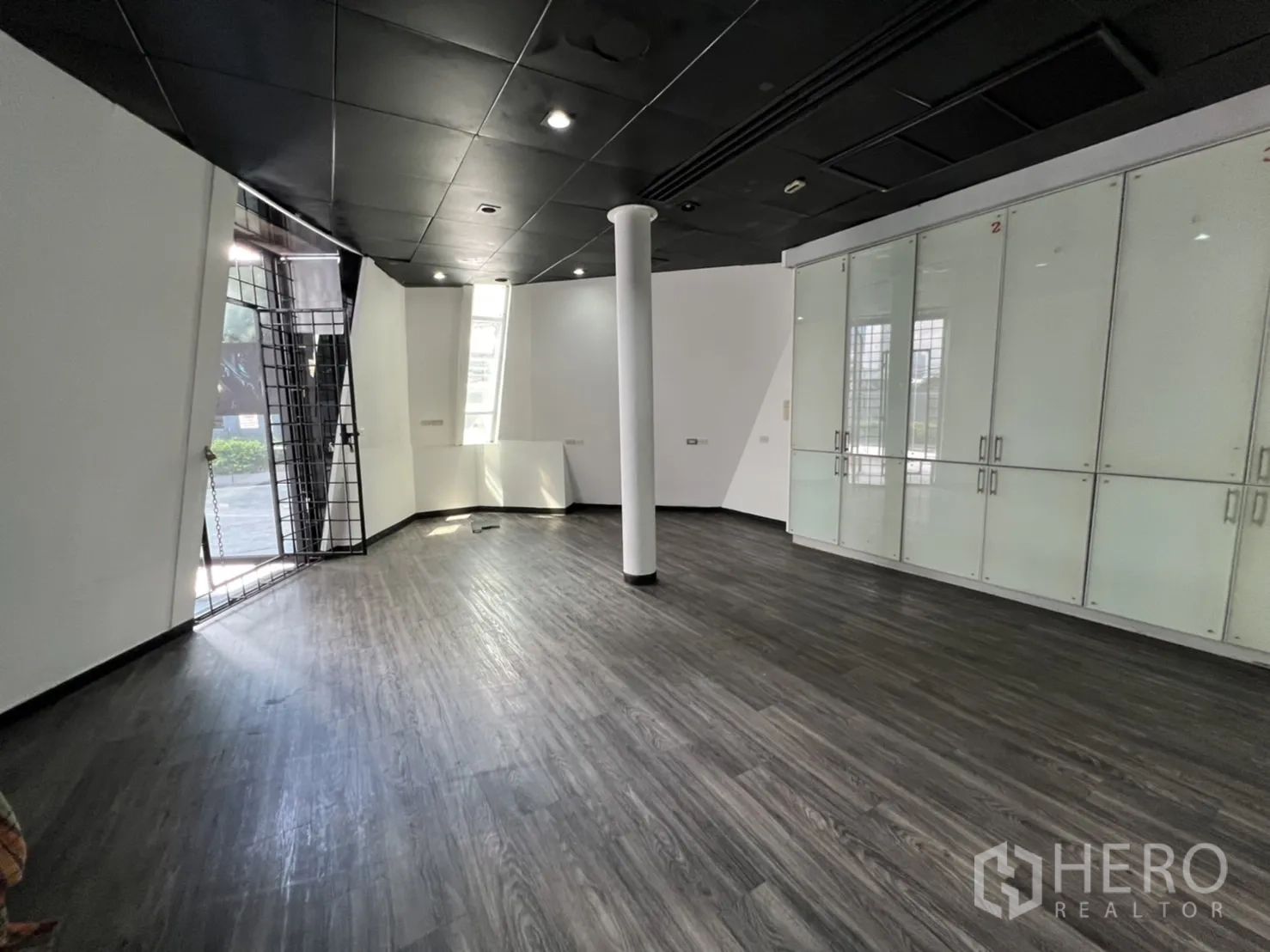 พื้นที่ขายปลีก ให้เช่าในSathon, Bangkok - ฮอลล์ค้าปลีกชั้นล่าง มีตู้กระจก เสา และประตูกรงโลหะสู่ด้านนอก