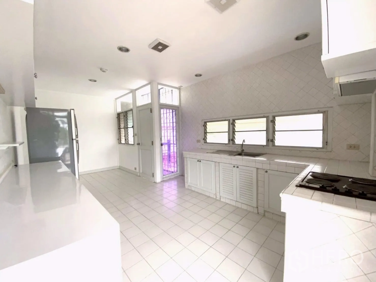 คอนโด ให้เช่าในWatthana, Bangkok - ครัวแยกโทนสีขาว เคาน์เตอร์ยาว เตาแก๊ส ตู้เย็น และหน้าต่างบานเกร็ด