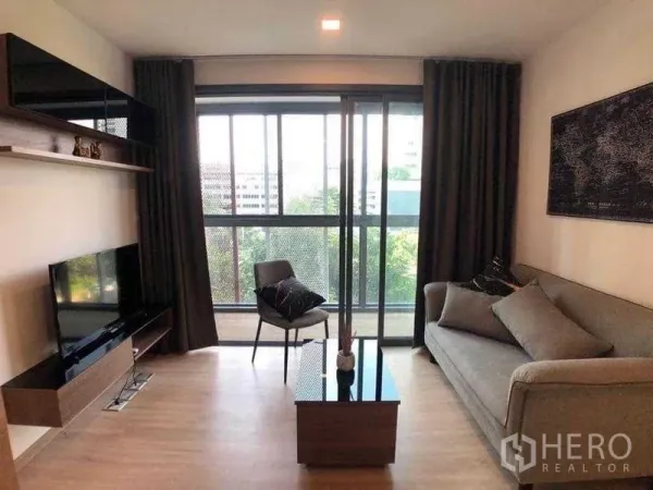 คอนโด ให้เช่าในWatthana, Bangkok - ห้องนั่งเล่นสว่าง มีทีวี ชั้นวาง โซฟา และประตูกระจกสไลด์ออกระเบียง