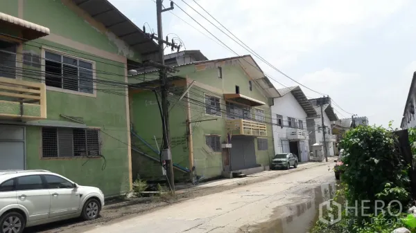 Factory for rent in Lam Luk Ka, Pathum Thani - Row of factory buildings with gabled roofs along an industrial lane in Lam Luk Ka, Pathum Thani.