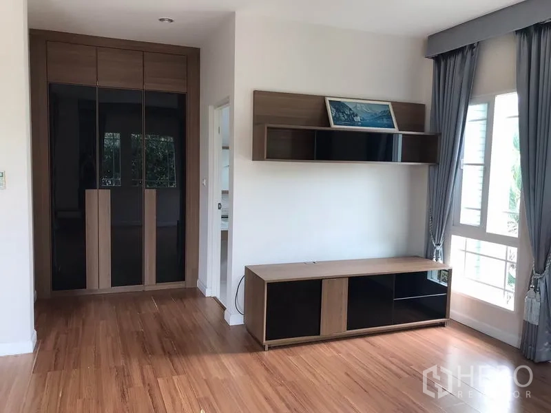 Detached House for rent in Khlong Sam Wa, Bangkok - Bedroom corner showing built-in wardrobe, TV cabinet and shelves.