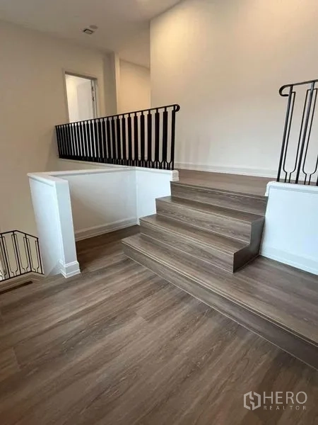 Detached House for rent in Saphan Sung, Bangkok - Upper landing with wooden steps and black metal balustrade.