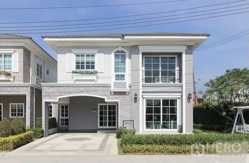 Detached House for rent in Nonthaburi - Front exterior of a two-storey detached house with large windows and covered carport in Pak Kret, Nonthaburi.