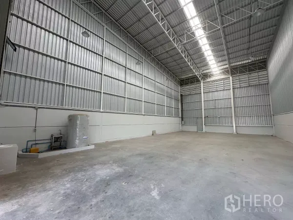 货栈 出租在Wang Noi, Phra Nakhon Si Ayutthaya - 高挑仓库内景，金属墙体、采光带与抛光混凝土地面。