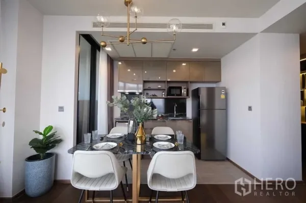 คอนโด ให้เช่าในKhlong Toei, Bangkok - ห้องรับประทานอาหารสมัยใหม่และครัวแบบเปิด โคมไฟทอง และตู้เย็นขนาดใหญ่
