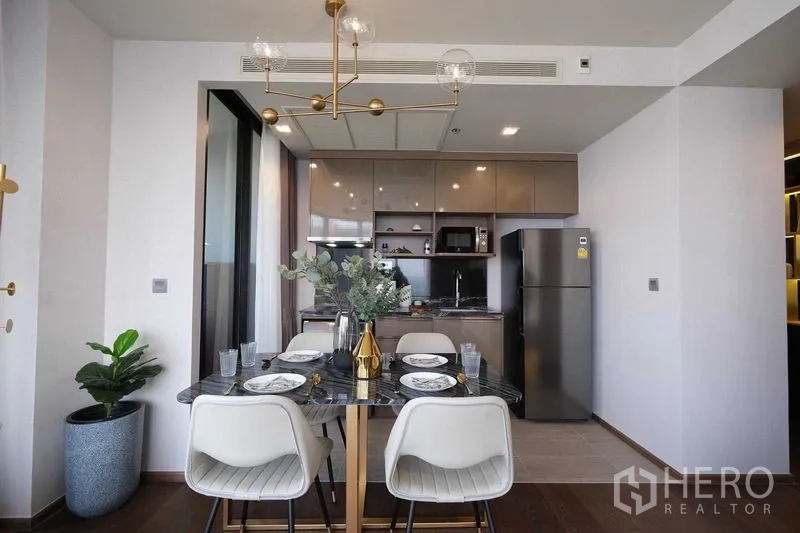 คอนโด ให้เช่าในKhlong Toei, Bangkok - ห้องรับประทานอาหารสมัยใหม่และครัวแบบเปิด โคมไฟทอง และตู้เย็นขนาดใหญ่