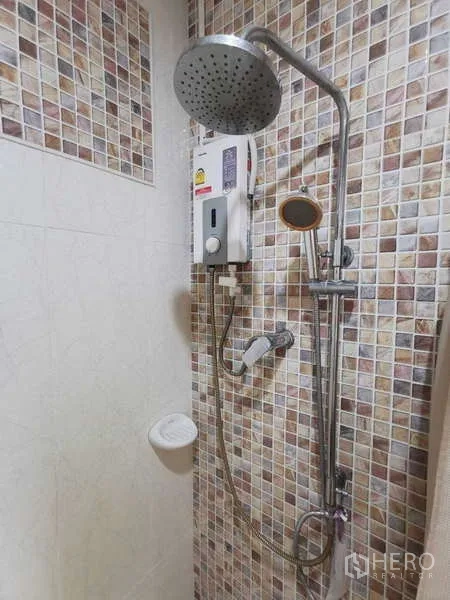 ทาวน์เฮาส์ ให้เช่าในChatuchak, Bangkok - ภาพระยะใกล้ของฝักบัวเรนชาวเวอร์และเครื่องทำน้ำอุ่นบนผนังโมเสก.