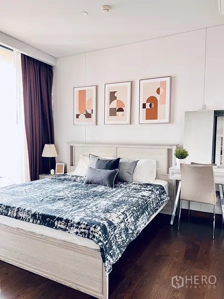 คอนโด ให้เช่าหรือขายในKhlong Toei, Bangkok - ห้องนอนกว้างตกแต่งภาพศิลป์ เตียงใหญ่ โต๊ะเครื่องแป้ง และพื้นไม้สีเข้ม