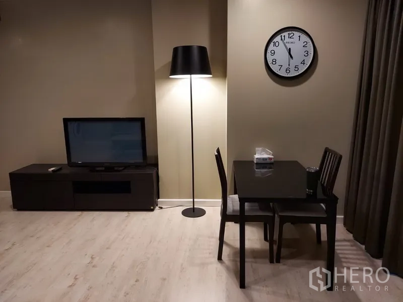 คอนโด ให้เช่าในPhaya Thai, Bangkok - มุมนั่งทานสำหรับสองที่ พร้อมโคมไฟตั้งพื้น นาฬิกาแขวน และชั้นวางทีวี