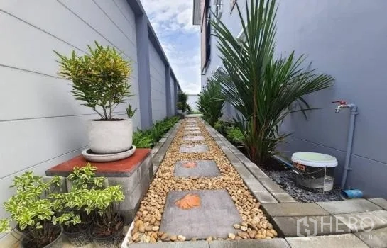 联排别墅 出租或出售在Saphan Sung, Bangkok - 曼谷Saphan Sung联排别墅侧院步道，铺设踏石、卵石与盆栽景观。