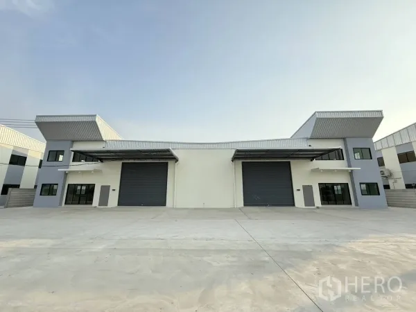 工厂 出租在Bang Phli, Samut Prakan - 邦普里独栋仓库外立面，双大型卷闸门与宽阔混凝土堆场。