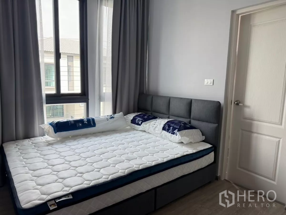 Detached House for rent in Bang Phli, Samut Prakan - Second bedroom with large corner windows, mattress and grey headboard.