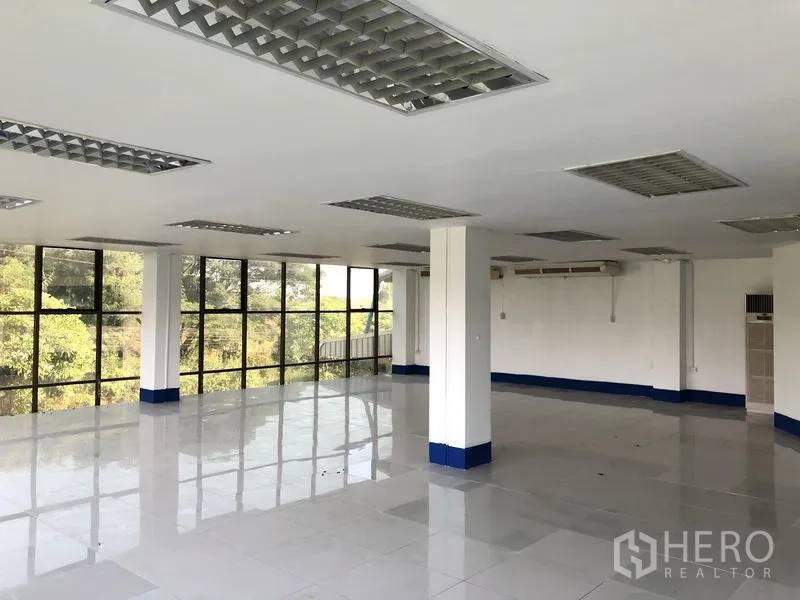 Warehouse for rent in Sai Mai, Bangkok - Bright corner office with floor-to-ceiling windows and glossy tiled floors.
