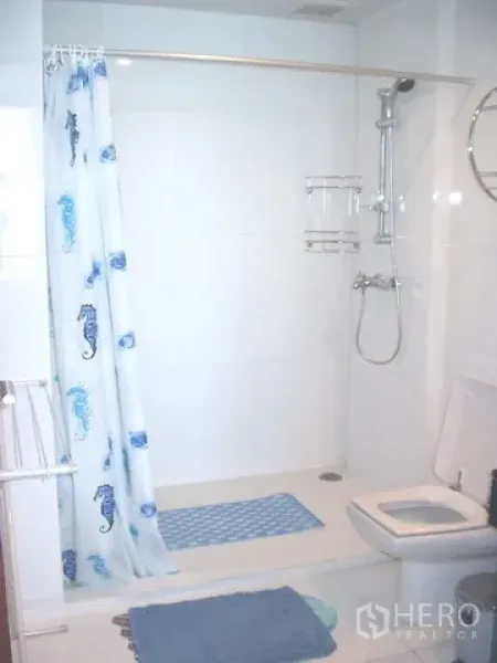 Condominium for rent in Pathum Wan, Bangkok - Clean white bathroom with walk-in shower, curtain and toilet.