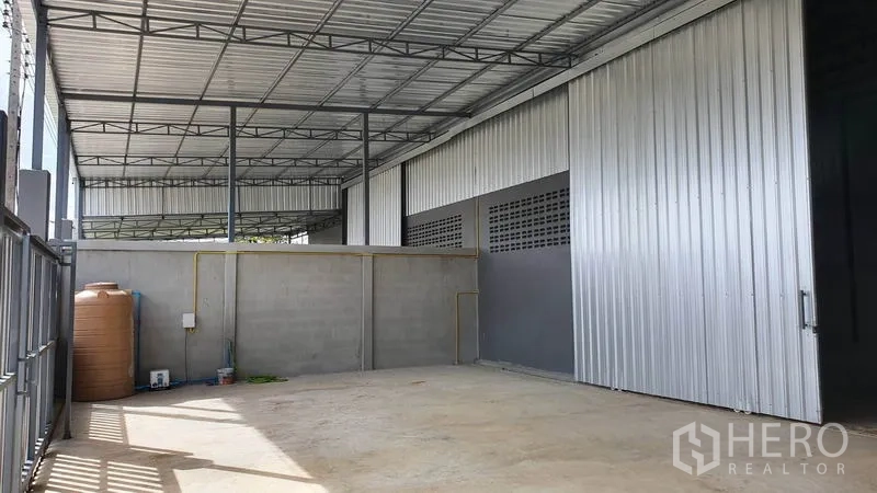 คลังสินค้า ให้เช่าในLam Luk Ka, Pathum Thani - ลานบริการด้านข้าง มีแทงก์น้ำ สายยูทิลิตี้ และผนังเมทัลชีทใต้กันสาด