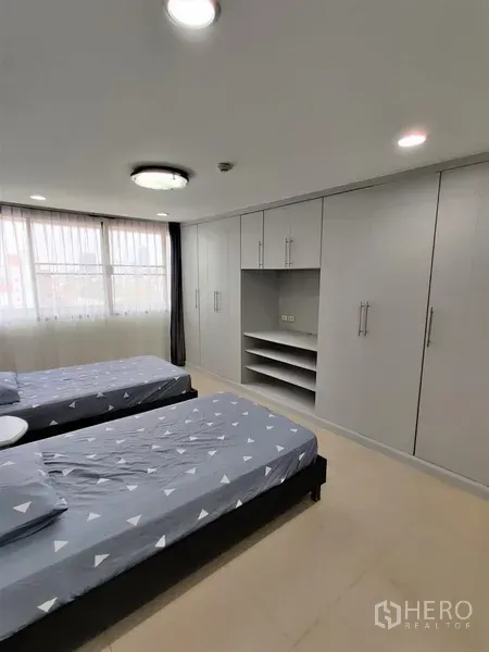 คอนโด ให้เช่าในWatthana, Bangkok - ห้องนอนเตียงเดี่ยวคู่สว่างด้วยหน้าต่างบานใหญ่ มีตู้เสื้อผ้าบิลท์อินเต็มผนัง