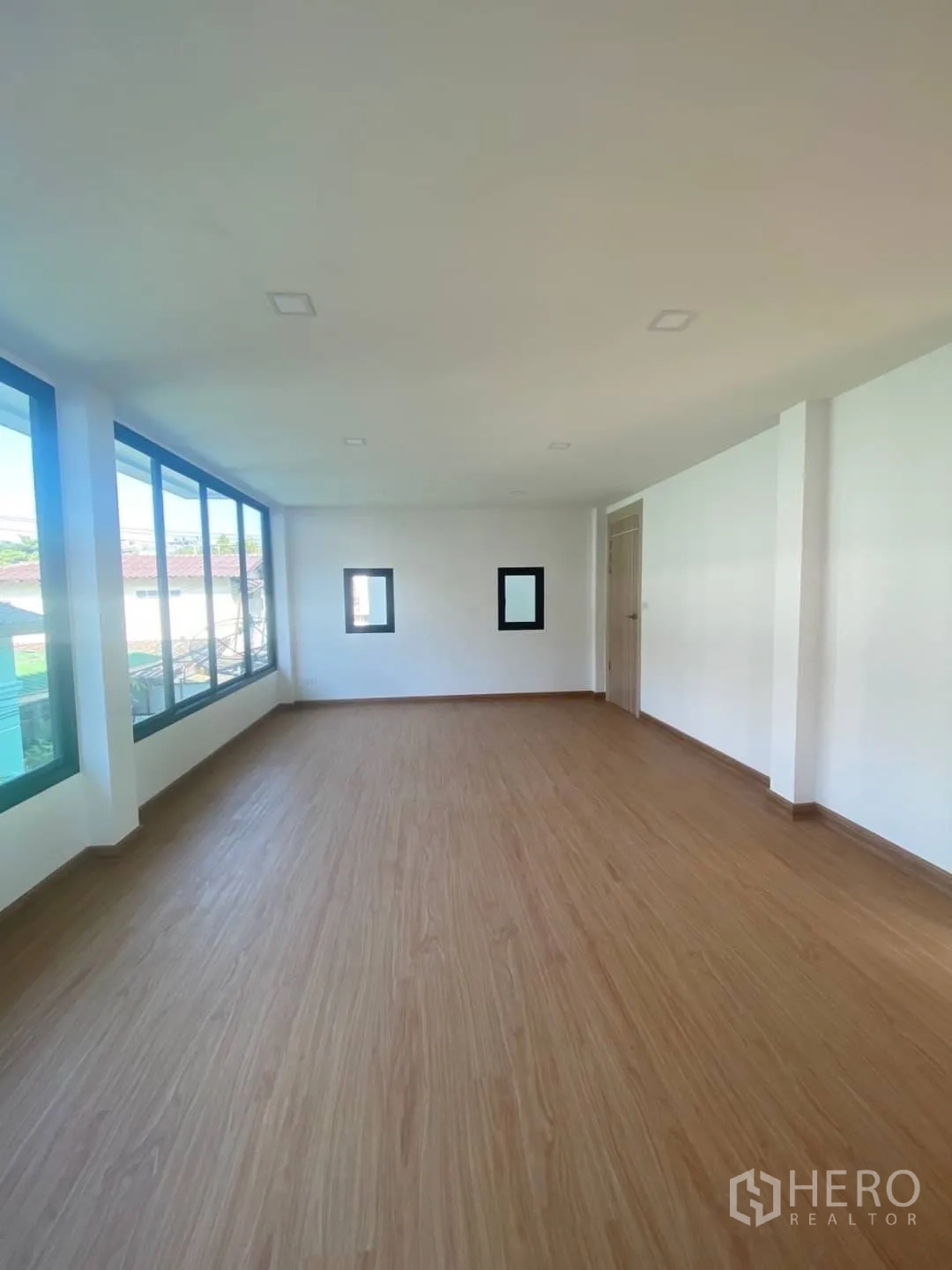 Home Office for sale - Open-plan office floor with wall-to-wall glazing and wood-look flooring.