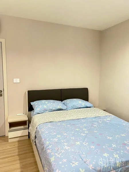 Townhouse for rent in Saphan Sung, Bangkok - Simple bedroom with double bed, pastel bedding and a bedside table.