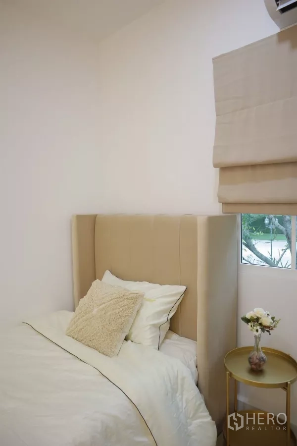 Detached House for rent in Bang Phli, Samut Prakan - Cozy single bedroom with padded headboard and round side table by a window.