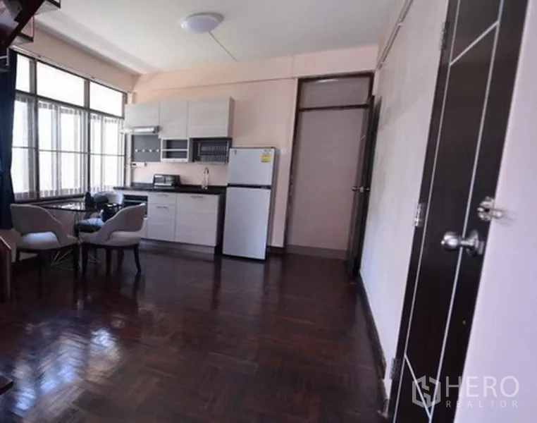 Detached House for rent in Bang Na, Bangkok - Light-filled kitchen-dining room with seating for two and dark parquet flooring.
