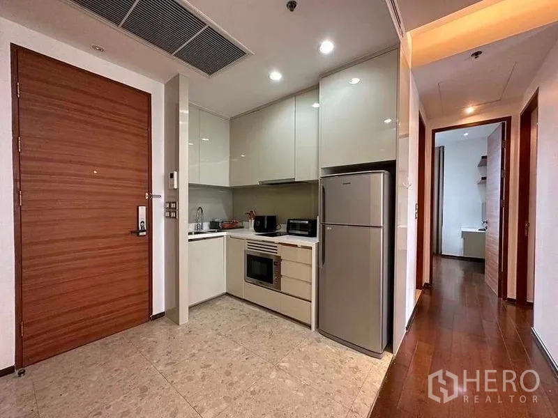 คอนโด ให้เช่าในKhlong Toei, Bangkok - ครัวรูปตัว L ตู้บิวท์อิน เตาอบ และตู้เย็นเต็มขนาด ใกล้ประตูทางเข้า