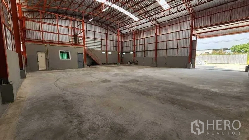 Warehouse for rent in Nong Chok, Bangkok - Spacious warehouse interior with red steel trusses, high roof, and mezzanine office.