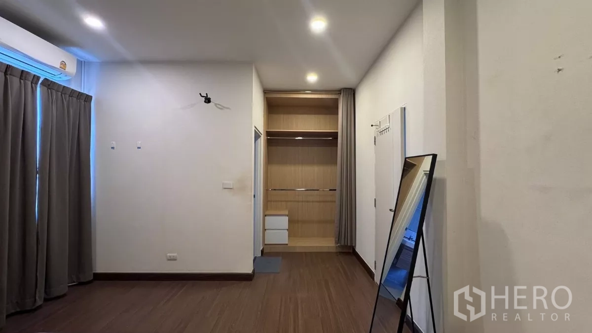 บ้าน ให้เช่าหรือขายในSaphan Sung, Bangkok - ห้องนอนขนาดใหญ่พร้อมตู้เสื้อผ้าเปิดโล่งบิลท์อิน กระจกยืน และผ้าม่านกันแสงสีเข้ม.