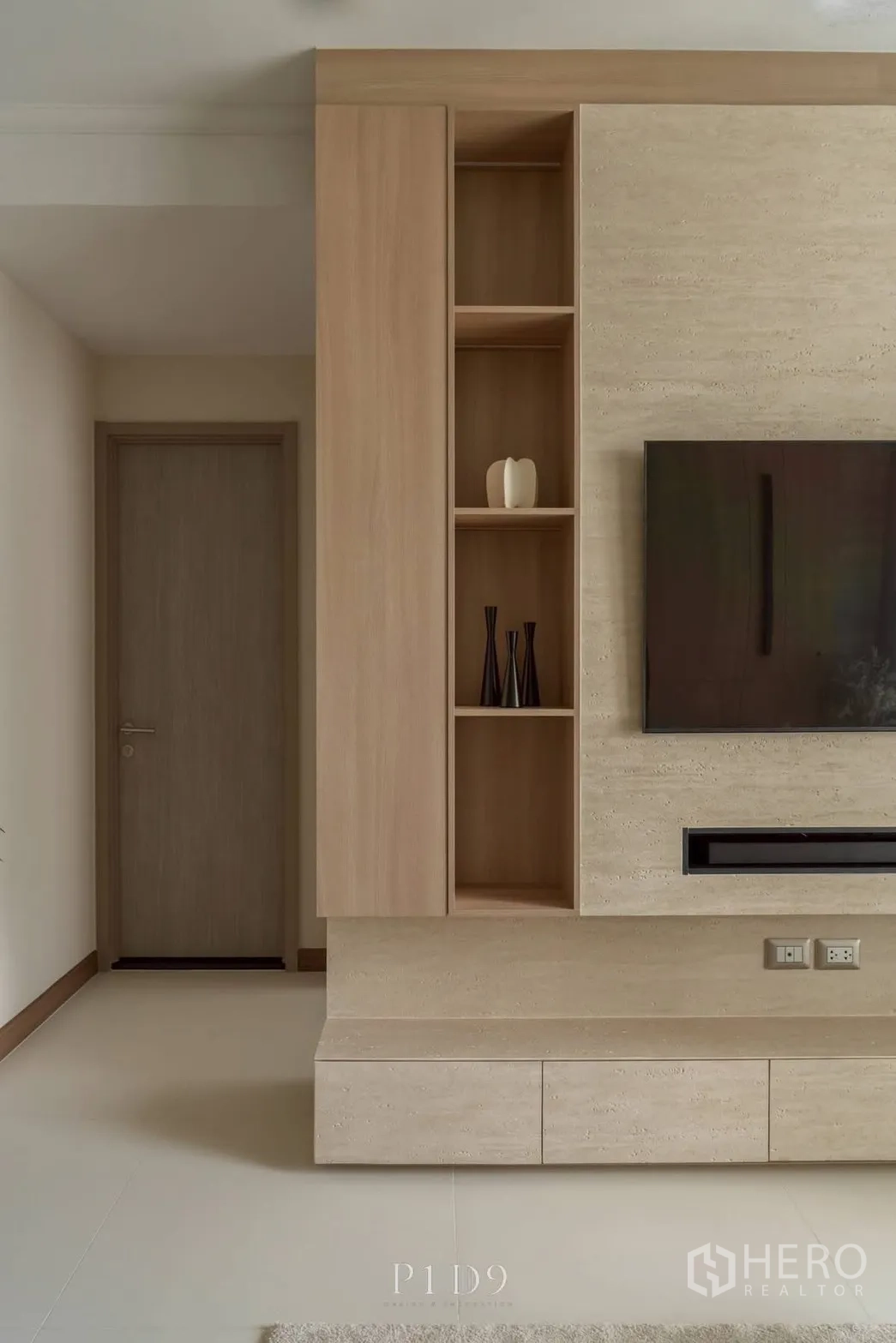 Condominium for rent in Watthana, Bangkok - Built-in TV wall with shelving and textured panels in the living room.