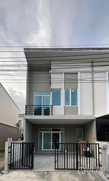 Townhouse for rent in Bang Phli, Samut Prakan - Front elevation of the townhouse with driveway gate and covered parking.