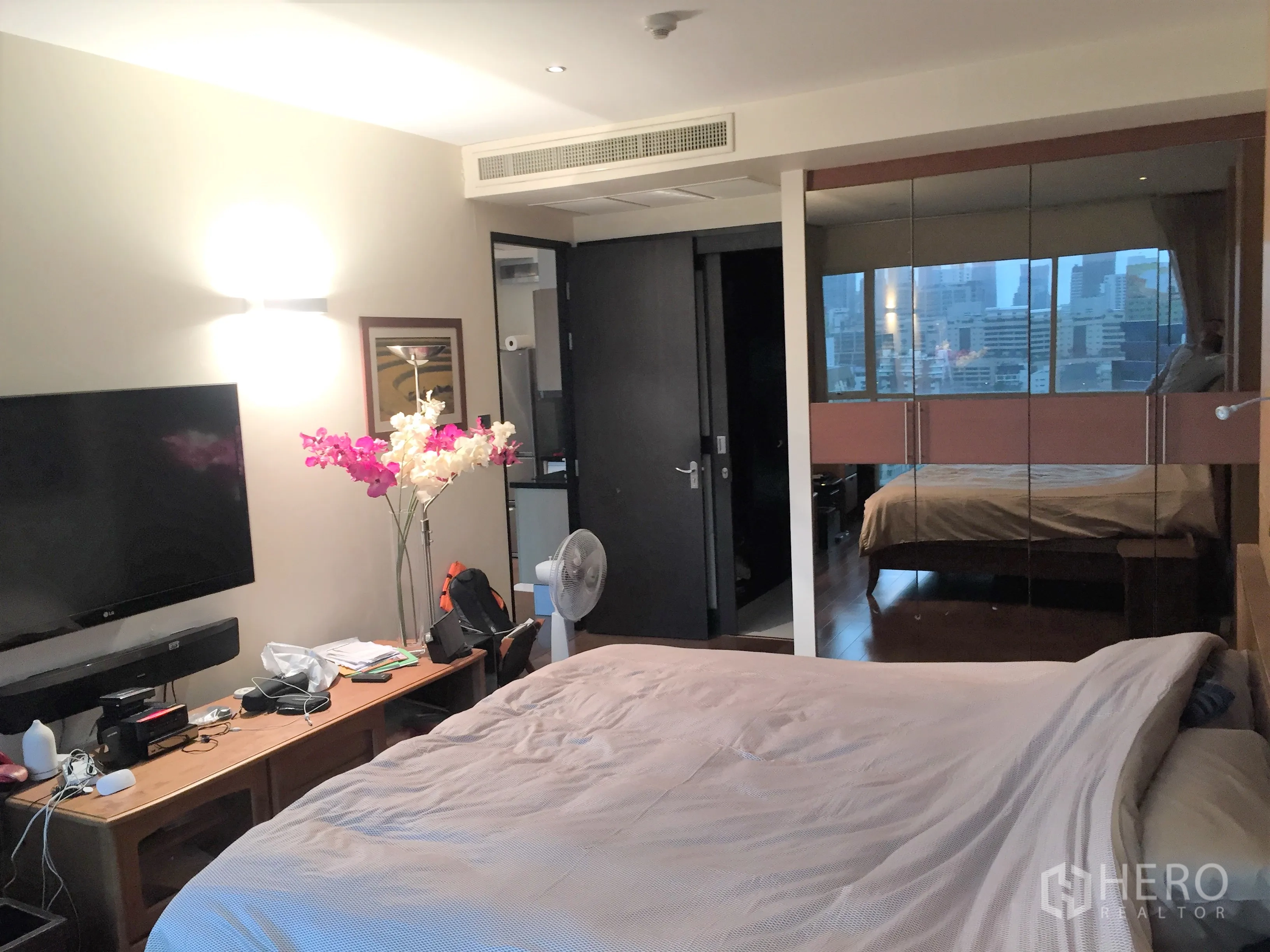 คอนโด ขายในPathum Wan, Bangkok - ห้องนอนหลักพร้อมทีวีติดผนังและตู้เสื้อผ้าบานกระจก