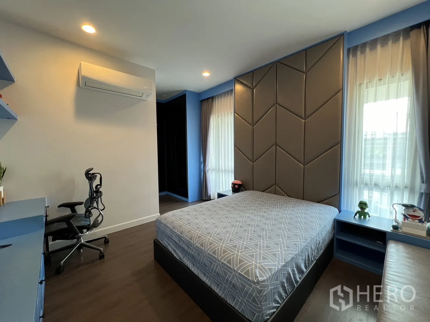 Detached House for rent or sale in Bang Kapi, Bangkok - Third bedroom in blue tones with padded headboard and study desk.