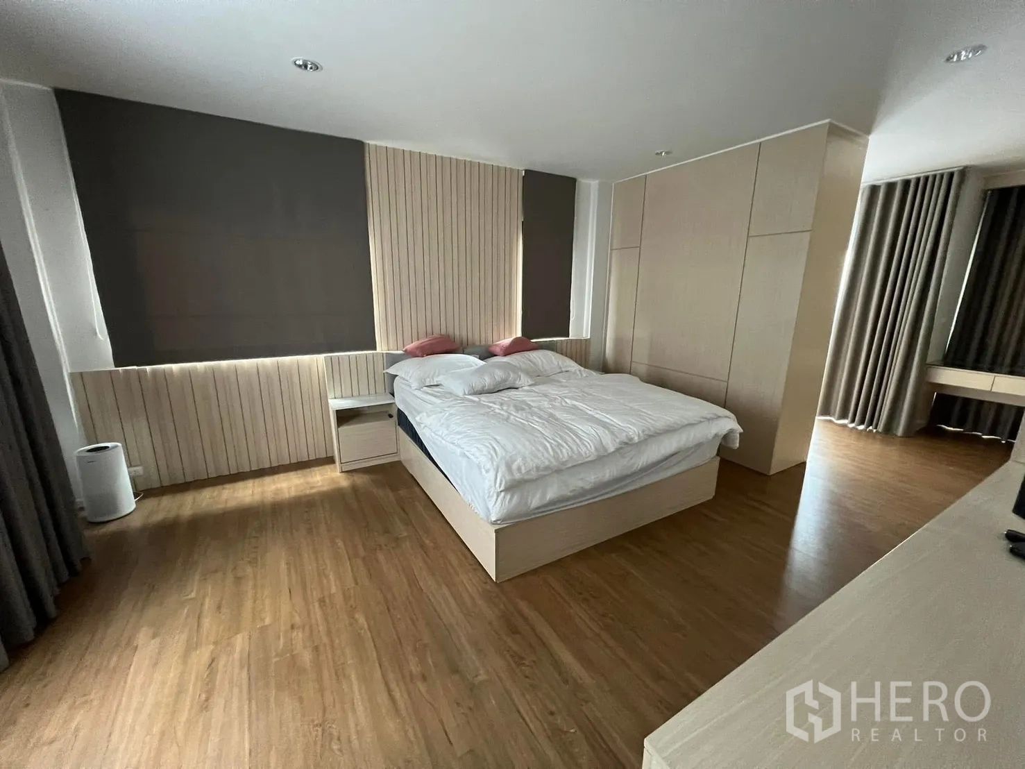 Semi-detached House for rent in Saphan Sung, Bangkok - Spacious master bedroom with wood floors, built-in wardrobes, and blackout curtains.