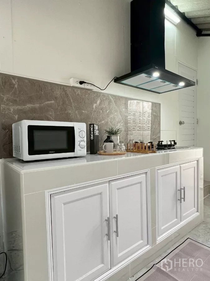 บ้าน ให้เช่าในHuai Khwang, Bangkok - ครัวขนาดกะทัดรัด ตู้บิวท์อินสีขาว ไมโครเวฟ ผนังหินอ่อน และเครื่องดูดควัน