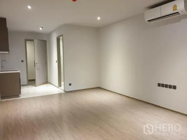 Condominium for sale in Watthana, Bangkok - Spacious open living area facing the pantry kitchen and bathroom doorway with AC installed.