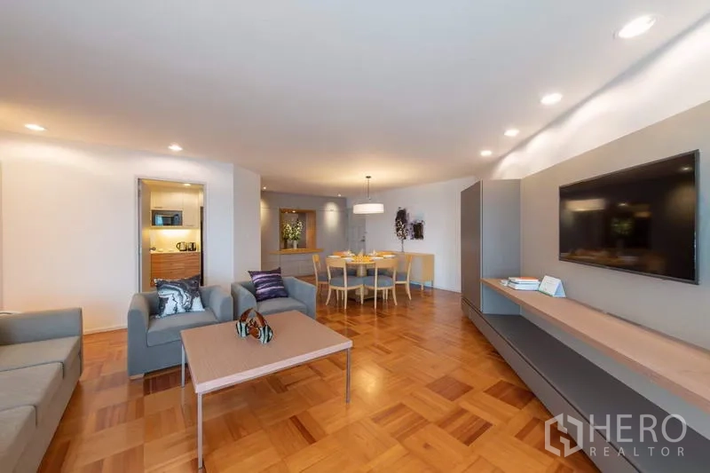 Apartment for rent - Spacious living and dining area with parquet floors, recessed lighting, gray sofas, TV wall and coffee table.