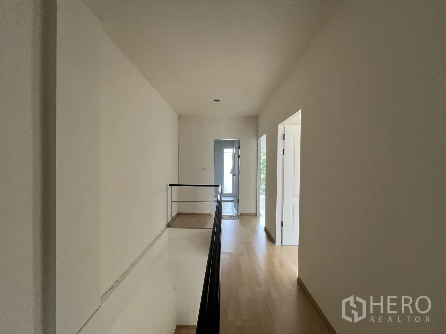 Townhouse for rent in Suan Luang, Bangkok - Stair landing with window and green curtains.