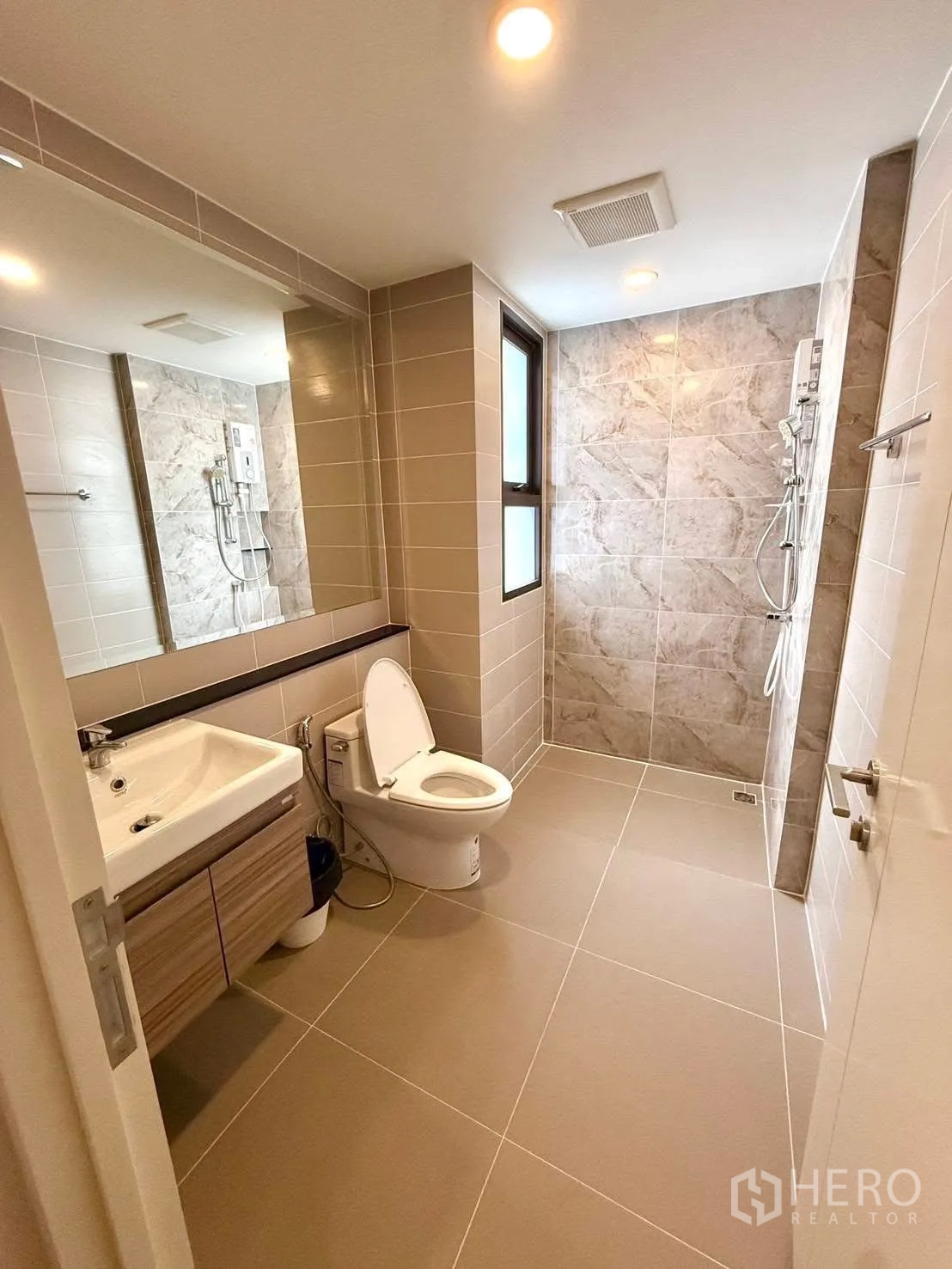 Detached House for rent or sale in Wang Thonglang, Bangkok - Bright bathroom with large mirror, vanity, toilet and walk-in shower.