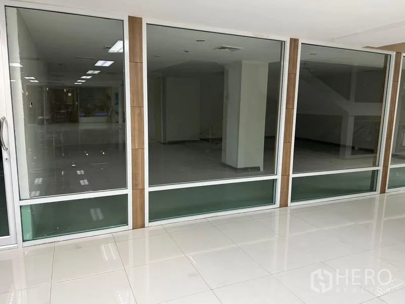 办公空间 出租在Bang Rak, Bangkok - 办公室整面玻璃门面与滑动门，临瓷砖走道。