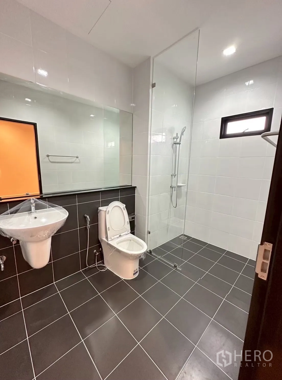 สำนักงานที่บ้าน for rent in Lat Phrao, Bangkok - ห้องน้ำสมัยใหม่พร้อมตู้ shower กระจก กระจกเงาบานยาว และพื้นกระเบื้องสีดำ.