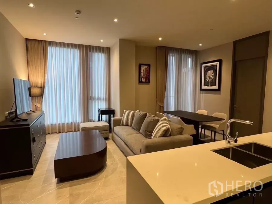 คอนโด ให้เช่าในWatthana, Bangkok - ห้องนั่งเล่นแสงอบอุ่น พร้อมโซฟา ตู้วางทีวี โต๊ะกลาง และผ้าม่านโปร่งสูงจรดเพดาน