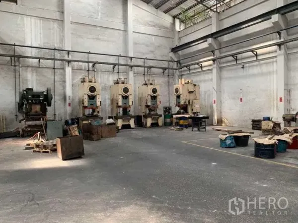 工厂 出租在Samut Prakan - 一排重型冲床沿高墙工业区域排列。