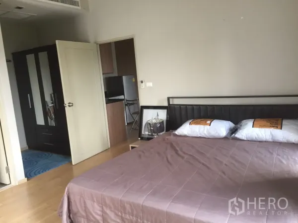 คอนโด ให้เช่าในWatthana, Bangkok - ห้องนอนพร้อมเตียงใหญ่ ตู้เสื้อผ้า และประตูสู่ครัวกะทัดรัด