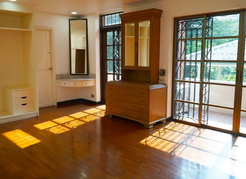 Townhouse for rent in Pathum Wan, Bangkok - Sunlit bedroom with built-in vanity and balcony access.