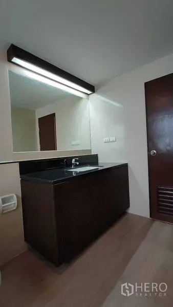 คอนโด ให้เช่าในKhlong Toei, Bangkok - มุมอ่างล้างหน้าพร้อมกระจกยาวมีไฟ และท็อปสีเข้มในห้องน้ำคอนโด