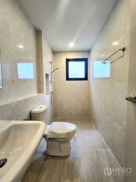 Detached House for rent in Bang Phli, Samut Prakan - Light-tone bathroom with walk-in shower, window and sanitary ware.