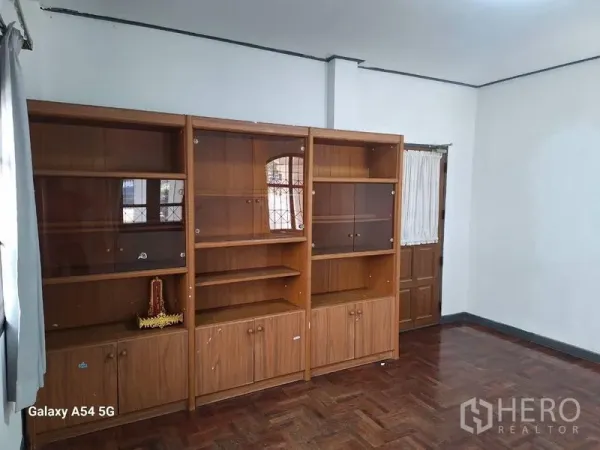 独立式住宅 出租在Bang Na, Bangkok - 空置客厅，内置木质展示柜与人字拼木地板。