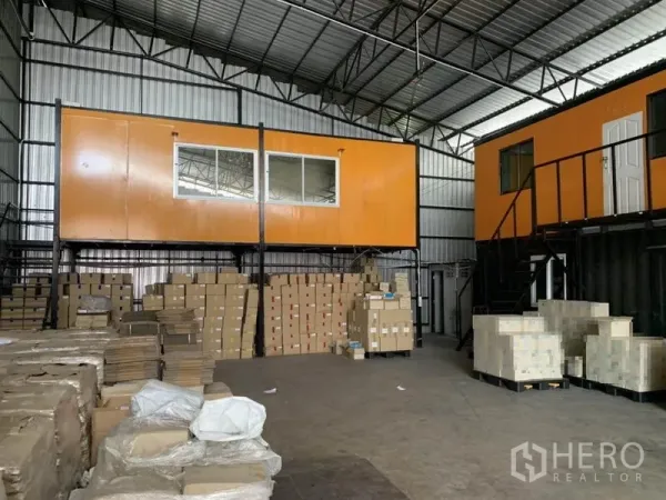 Warehouse for rent in Bang Kapi, Bangkok - Dual elevated office pods and inventory stacks under a metal roof in a Bangkok warehouse.